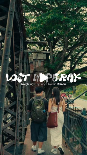 Two travellers walking onto a leafy bridge in the Lost in Perak film poster.